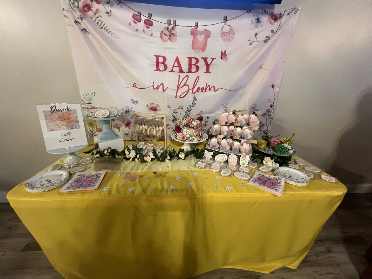 Baby in Bloom dessert table with cookies, cake stands, and floral backdrop