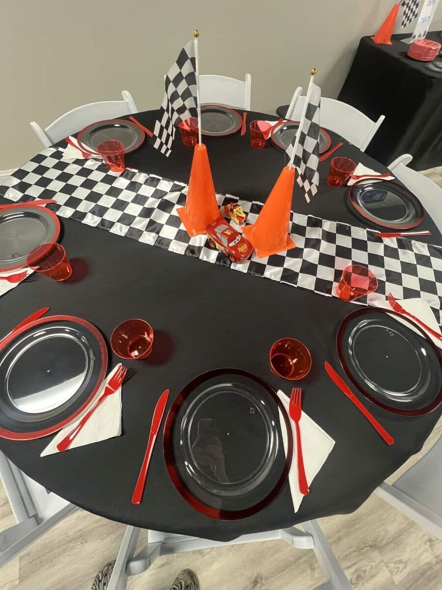 Racing Cars theme table setting with checkered flag runner and orange cones